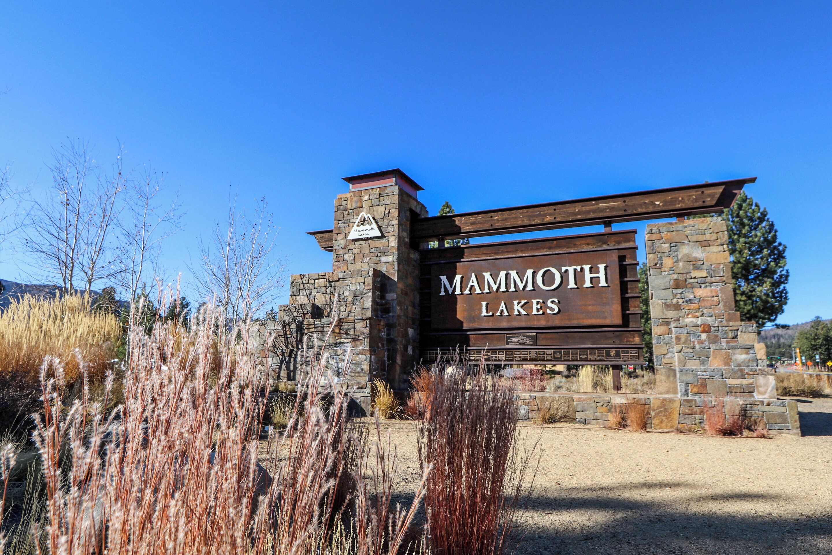 A sign for Mammoth Lakes with a stone and wood structure.