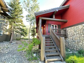 A wooden staircase leading to a red building with a stone wall. - Large Family Home. Washer/Dryer, Pool Table & Gas Grill. Mountain Views (Mammoth Lakes)