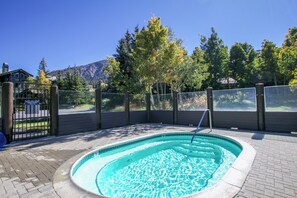 A swimming pool with a tiled edge, surrounded by a brick patio, and enclosed by a wooden fence with a gate. - Large Family Home. Washer/Dryer, Pool Table & Gas Grill. Mountain Views (Mammoth Lakes)