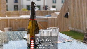 Une bouteille de vin, deux verres et une table ornée du logo de la société Island Holiday Company.