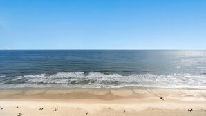 A beach with a clear sky, calm sea, and a sandy shore. - Oceanfront Crescent Beach 1K 2Q - Crescent Shores - 1609 (North Myrtle Beach)
