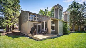 Ein modernes, zweistöckiges Haus mit Terrasse, großen Fenstern und einem gepflegten Rasen.