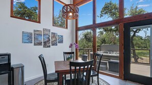 Un comedor con mesa de madera, sillas y cuadros en la pared.