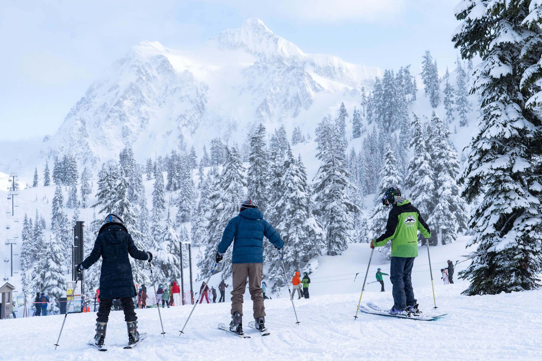 A snowy mountain scene with skiers and a ski lift in the background.