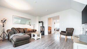 Een moderne woonkamer met een bank, salontafel en open haard.