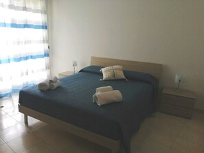 2 habitaciones, escritorio y tabla de planchar con plancha