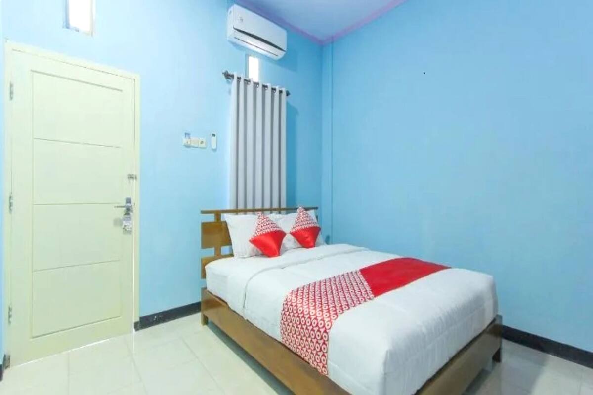 Une chambre à coucher avec un lit, une porte et un appareil de climatisation.