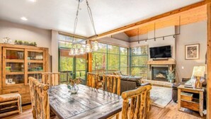 A spacious living room with a wooden dining table, chairs, and a fireplace. - Lovely Townhome a Half-mile From Keystone Gondola W/shared Hot-tub & Excellent Views (Keystone)