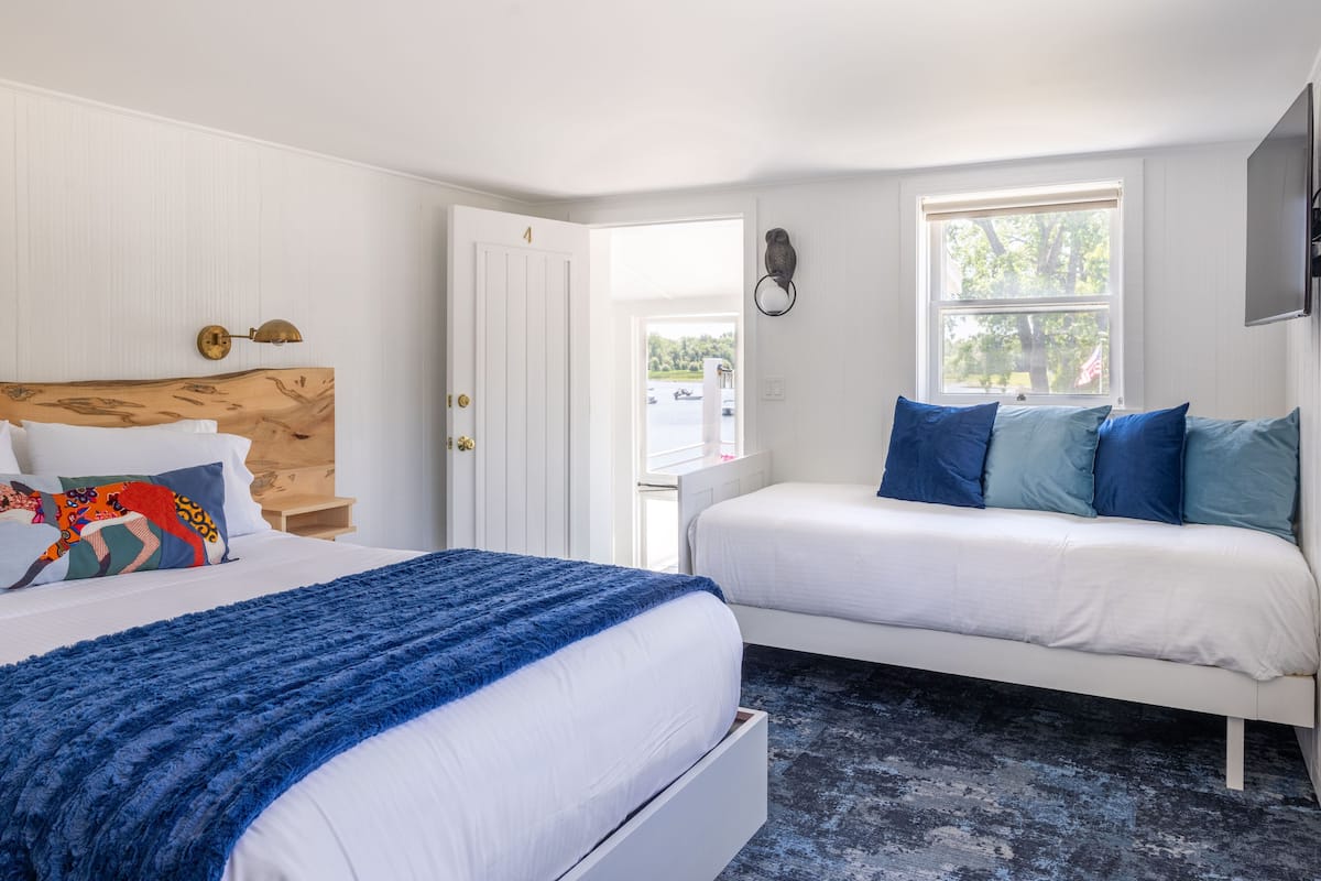 Ein Schlafzimmer mit Bett, Sofa, Fenster und Tür.