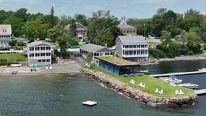 A waterfront property with a dock, boats, and a building with a green roof. - The North Hero House Inn & Restaurant (North Hero)
