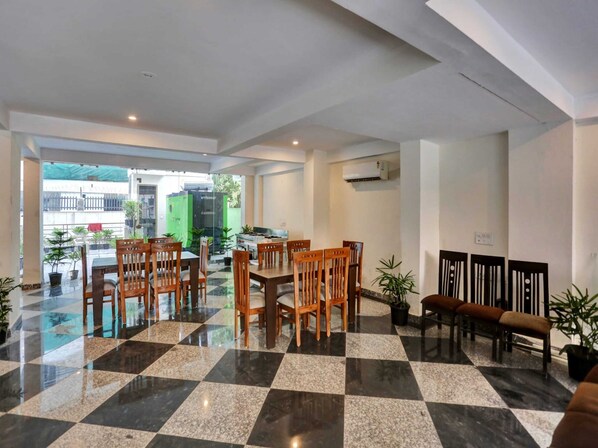 A spacious lobby with a checkered floor, wooden chairs, and a seating area with benches.