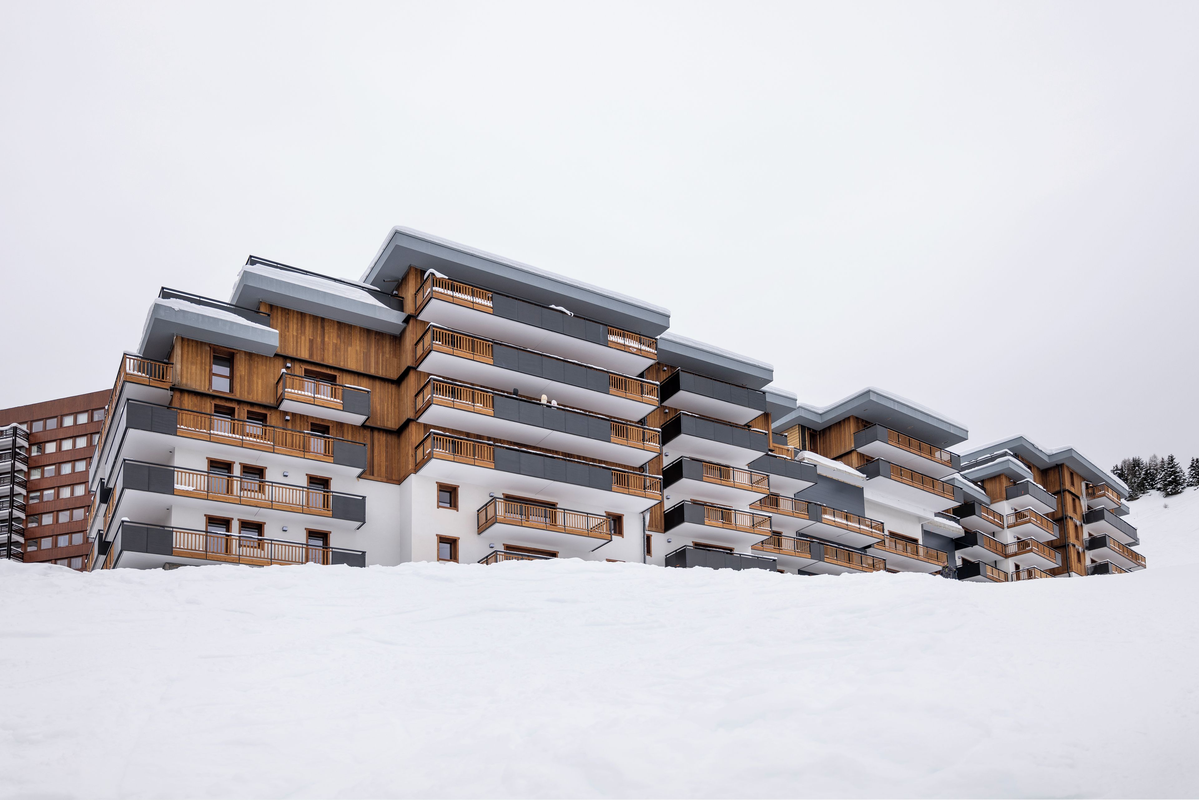 Ein mehrstöckiges Gebäude mit Balkonen, umgeben von Schnee.