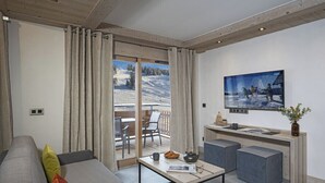 Een moderne woonkamer met een bank, een salontafel en zicht op een besneeuwd landschap door een schuifdeur.