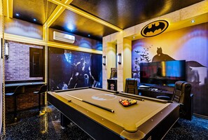 Enjoy a game of pool or relax in the stylish billiards room with a large screen and comfortable seating.
