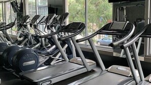 A gym with multiple treadmills and exercise equipment, large windows, and a television screen. - In Polanco, pool, rooftop, gym, 24/7 security (Ciudad de México)