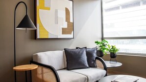 A modern living room with a sofa, a small round table, a floor lamp, and a large abstract painting on the wall. - In Polanco, pool, rooftop, gym, 24/7 security (Ciudad de México)