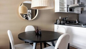 A modern kitchen with white cabinets, a stainless steel range hood, and a round dining table with white chairs. - In Polanco, pool, rooftop, gym, 24/7 security (Ciudad de México)
