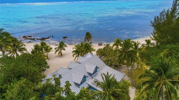 Une vue sur la plage, avec un bâtiment entouré de palmiers.