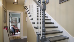 A staircase with a handrail, carpeted steps, and a white railing.