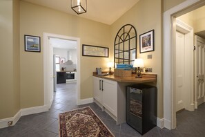 Stylish hallway leads to a well-equipped kitchen area with a countertop, refrigerator, and storage.