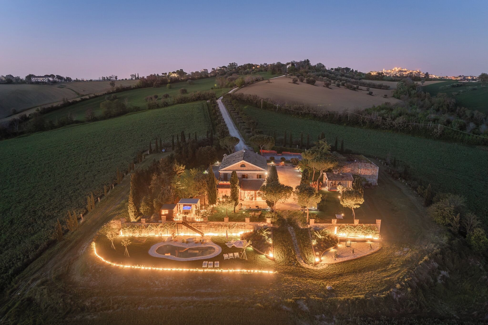 A large estate with multiple buildings, a landscaped garden, and a winding driveway.