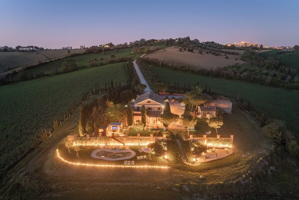 A large estate with multiple buildings, a landscaped garden, and a winding driveway.
