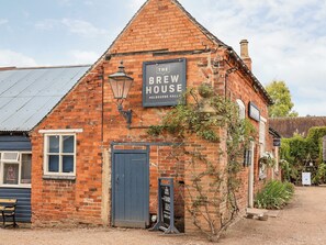 A brick building with a sign reading "The Brew House Melbourne Hall".