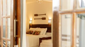Een hotelkamer met twee bedden, houten hoofdeinden en wandlampen.
