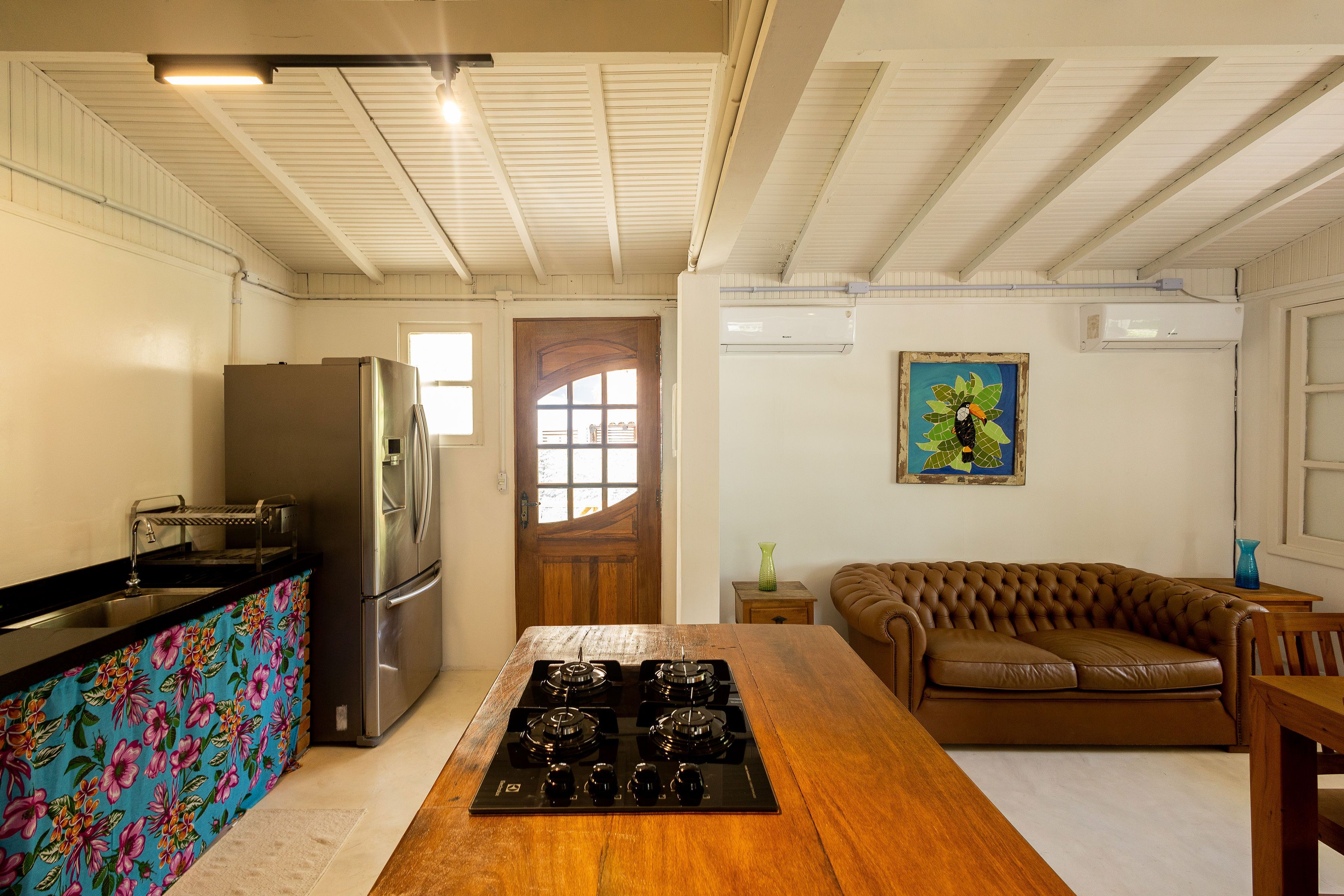 A kitchen with a wooden island, stainless steel appliances, and a colorful backsplash.
