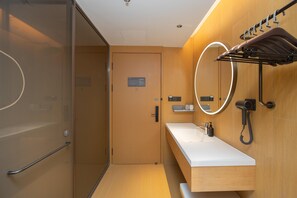 A modern bathroom with a glass shower enclosure, a wooden vanity with a white countertop, and a towel rack with a towel hanging. - Ji Hotel Hefei Mingzhu Square (Hefei)