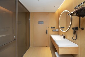 A modern bathroom with a wooden vanity, a mirror with a circular light, and a towel rack. - Ji Hotel Hefei Mingzhu Square (Hefei)