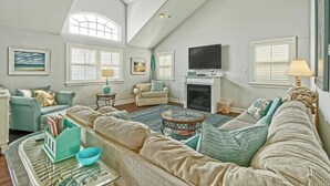 A spacious living room with a high ceiling, large windows, a fireplace, and a television. - Bright and Airy Condo.  One block to the Beach.  Great location. (Sea Isle City)