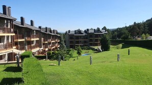 A multi-story hotel with balconies and a well-maintained lawn.
