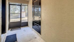 Ein Flur mit einer zur Garage führenden Tür, einem kleinen Teppich auf dem Boden und einer Deckenleuchte.