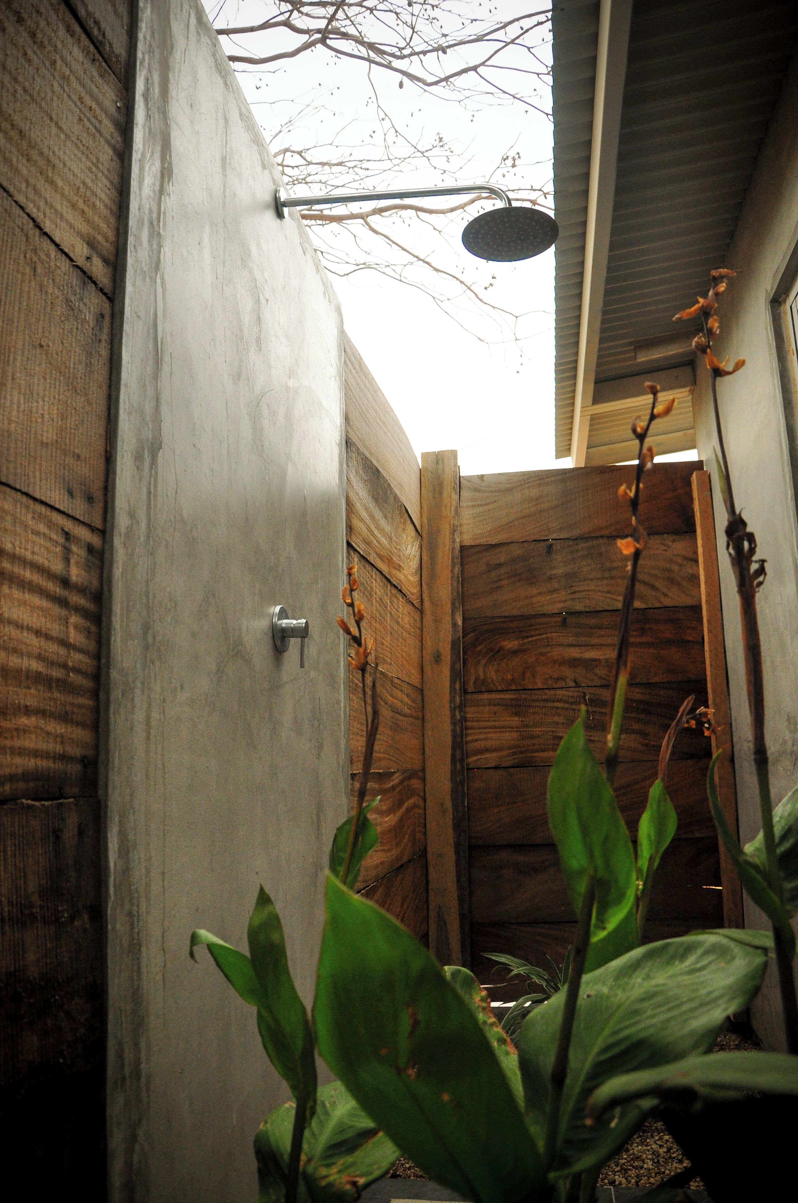 A wooden door with a metal handle, a concrete wall, and a wooden fence.