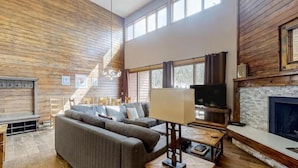 A spacious living room with a large sofa, a TV, and a fireplace. - 2 Bedroom Montezuma Condo at Lakeside Village - Shuttle to Slopes! (Keystone)