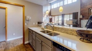 A modern kitchen with a large island, double sink, and pendant lighting. - 2 Bedroom Montezuma Condo at Lakeside Village - Shuttle to Slopes! (Keystone)