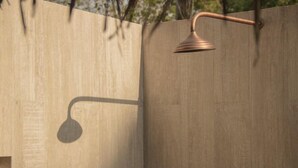 A modern shower enclosure with a curved showerhead and a wall-mounted control lever. - Savanna Orinoquia Lodge (Orocue)