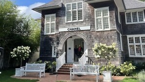 Un bâtiment à deux étages, avec une enseigne portant l’inscription « CHANEL » au-dessus de l’entrée.