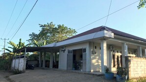 A two-story building with a covered entrance and a dirt driveway.