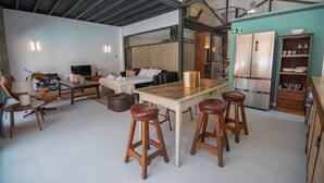 A modern kitchen with a wooden table, bar stools, a refrigerator, and a staircase leading to an upper level. - Elegant and luxurious apartment in Madrid Tempory (Madrid)
