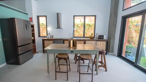 A modern kitchen with a central island, bar stools, a stainless steel refrigerator, and a view through large windows. - Elegant and luxurious apartment in Madrid Tempory (Madrid)