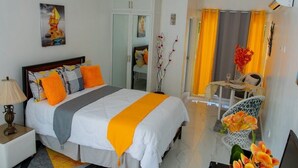 Une chambre d’hôtel avec un lit, une table de chevet et une petite table accompagnée d’une chaise.