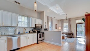 A spacious kitchen with white cabinetry, a stainless steel dishwasher, a built-in oven, and a microwave. - Cooper Young Vibes Su (Memphis)