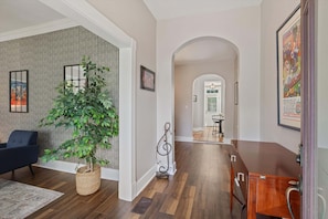 A modern living room with a large plant, a blue sofa, and a wooden coffee table. - Bungalow ON Overton Square (Memphis)