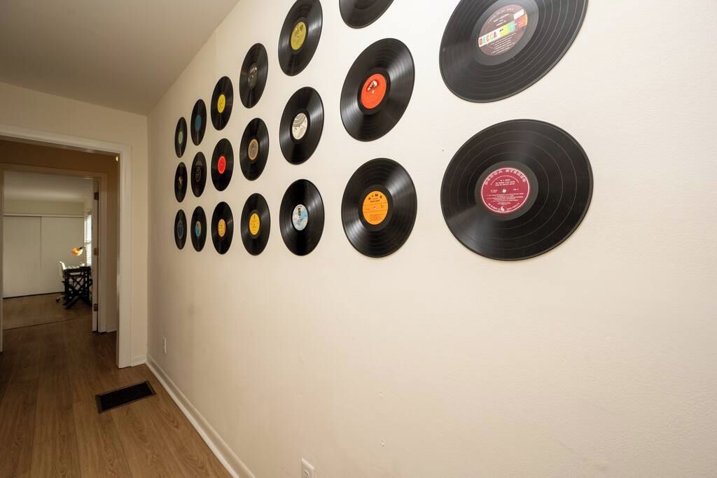 A wall with vinyl records arranged in a grid pattern.