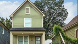 A two-story house with a front porch, a garage, and a small front yard.