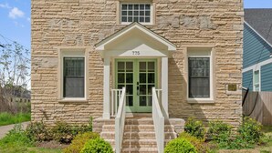 En bygning i sten med en grøn dør og nummer 775.