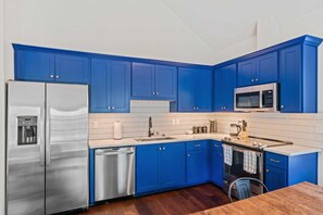 Enjoy cooking in this fully equipped kitchen with a refrigerator, oven, microwave, and sink.