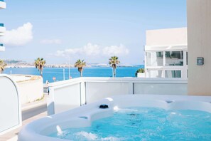 Ein Whirlpool mit Blick auf das Meer und Palmen.